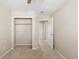 Carpeted bedroom with a ceiling fan, open closet, and entry to the hallway at 16643 E 101St Ave, Commerce City, CO 80022