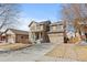 Charming two-story home featuring a stone facade, covered porch, and an attached two-car garage at 16643 E 101St Ave, Commerce City, CO 80022