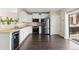 Kitchen with white cabinets, stainless steel appliances, and dark hardwood floors at 16643 E 101St Ave, Commerce City, CO 80022