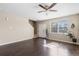 Open-concept living room with hardwood floors, a ceiling fan, and natural light at 16643 E 101St Ave, Commerce City, CO 80022