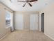 Carpeted main bedroom featuring a ceiling fan, large window with blinds and curtains and double door closets at 16643 E 101St Ave, Commerce City, CO 80022