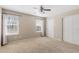 Carpeted main bedroom with two large windows, ceiling fan, and a double door closet at 16643 E 101St Ave, Commerce City, CO 80022