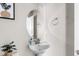 Stylish powder room featuring a pedestal sink, oval mirror, and modern fixtures at 16643 E 101St Ave, Commerce City, CO 80022