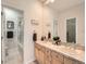 Well-lit bathroom with double sinks, wood cabinets, and a separate shower and toilet area at 30 Garfield St # B, Denver, CO 80206