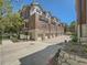 View of townhome exteriors with garages, balconies, and brick and stone details at 30 Garfield St # B, Denver, CO 80206
