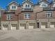 Exterior view of multi-story townhomes with garages and brick accents at 30 Garfield St # B, Denver, CO 80206