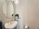 Cozy powder room features a pedestal sink, decorative mirror, and neutral color palette at 30 Garfield St # B, Denver, CO 80206