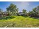 Spacious backyard with manicured lawn, mature trees, and a privacy fence at 7294 S Syracuse St, Centennial, CO 80112