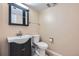Well-lit half bathroom featuring a modern vanity, toilet, and neutral decor at 7294 S Syracuse St, Centennial, CO 80112