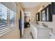 Bathroom with a double vanity, view into the main bedroom, and good natural light from the window at 7294 S Syracuse St, Centennial, CO 80112