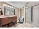 Updated bathroom with a glass-enclosed shower, wood vanity, and neutral color scheme at 7294 S Syracuse St, Centennial, CO 80112