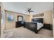 Comfortable main bedroom with a large bed, dark furniture, and ample natural light from two windows at 7294 S Syracuse St, Centennial, CO 80112