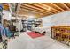 Unfinished basement with exposed ceiling, bed and storage area at 117 Nova Ct, Erie, CO 80516