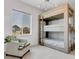Stylish bedroom with a bunkbed and a comfortable chair, illuminated by natural light at 117 Nova Ct, Erie, CO 80516