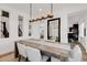 Stylish dining room with a long wooden table, upholstered chairs, and a modern chandelier at 117 Nova Ct, Erie, CO 80516