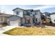 Charming two-story home with gray siding, stone accents, a two-car garage, and a welcoming front yard at 117 Nova Ct, Erie, CO 80516