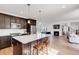 Open-concept kitchen with a spacious island, stainless steel appliances, and hardwood floors connecting to the living area at 117 Nova Ct, Erie, CO 80516