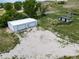 Aerial view of large barn with multiple garage doors and a gravel parking area at 14831 Riverdale Rd, Brighton, CO 80602