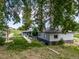 Exterior view of house with gray siding, outbuilding, and green yard at 14831 Riverdale Rd, Brighton, CO 80602
