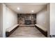 Cozy room featuring a unique stone fireplace, benches, and new flooring at 14831 Riverdale Rd, Brighton, CO 80602
