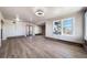 Spacious living room featuring a stone fireplace, new flooring, and large windows at 14831 Riverdale Rd, Brighton, CO 80602