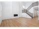 Spacious living room with hardwood floors, a modern fireplace, and an elegant staircase leading to the upper level at 16671 W 93Rd Ave, Arvada, CO 80007
