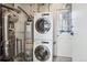 Basement laundry area with stacked washer and dryer, next to the water heater at 1100 Gaylord St, Denver, CO 80206
