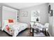 Bright bedroom featuring a functional desk and a comfortable murphy bed with floral comforter at 1100 Gaylord St, Denver, CO 80206