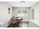 Bright dining area with a round wooden table, grey cushioned chairs, and a window view for delightful meals at 1100 Gaylord St, Denver, CO 80206