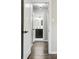 Hallway view of a bathroom featuring a dark vanity, white subway tiles, and modern fixtures at 1100 Gaylord St, Denver, CO 80206