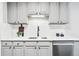 Well-lit kitchen with stainless steel sink, light grey cabinetry, and sleek countertops for a modern cooking experience at 1100 Gaylord St, Denver, CO 80206