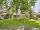 Spacious backyard with lush green grass, stepping stones and mature trees providing shade at 3265 S Ogden St, Englewood, CO 80113