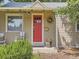 A detailed close up of the home's porch, showcasing the vibrant red front door and cozy seating at 3265 S Ogden St, Englewood, CO 80113