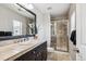 Bathroom featuring a shower with a glass door, tiled floors, and dark cabinetry at 150 S Harrison St # 9, Denver, CO 80209