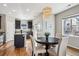 Open concept kitchen and dining area featuring dark cabinets, wood floors, and stylish light fixture at 150 S Harrison St # 9, Denver, CO 80209