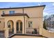 Tan two-story home featuring arched entryways and a balcony with black iron railings at 150 S Harrison St # 9, Denver, CO 80209