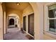 Arched entryway with double doors, and concrete walkway leading to a courtyard and neighboring buildings at 150 S Harrison St # 9, Denver, CO 80209