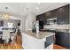 Kitchen featuring a large kitchen island, dark cabinets and stainless steel appliances at 150 S Harrison St # 9, Denver, CO 80209