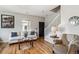 Living room with hardwood floors, a white sofa with patterned throw pillows, and a decorative mirror at 150 S Harrison St # 9, Denver, CO 80209