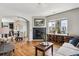 Cozy living room with fireplace, hardwood floors, and dining room access through an arched entryway at 150 S Harrison St # 9, Denver, CO 80209