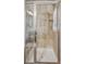 Glass enclosed shower with stylish tile work, built-in shelf, and modern shower head at 150 S Harrison St # 9, Denver, CO 80209