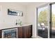 Stylish bar area featuring dark wood cabinets, a wine fridge, and access to a scenic balcony at 2321 S Acoma St, Denver, CO 80223