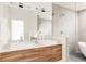 Modern bathroom featuring dual sinks, wood cabinets, a walk-in shower, and elegant finishes at 2321 S Acoma St, Denver, CO 80223