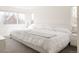 Bright, minimalist bedroom with a large window, plush bedding and light gray carpet at 2321 S Acoma St, Denver, CO 80223