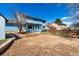 Large backyard features a blue house with mature tree providing ample shade at 2336 S Dawson Way, Aurora, CO 80014