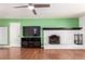 This living room boasts hardwood floors, white fireplace, bright green accent wall, and modern ceiling fan at 2336 S Dawson Way, Aurora, CO 80014