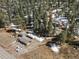 Aerial view of a secluded mountain home surrounded by dense pine trees, outbuildings and a scenic landscape at 28268 Shadow Mountain Dr, Conifer, CO 80433