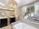 Bathroom showcasing dual vanities, a tub, and a window with views of the snowy landscape at 28268 Shadow Mountain Dr, Conifer, CO 80433