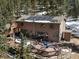 Inviting exterior featuring a multi-tiered deck, solar panels, and surrounded by lush greenery at 28268 Shadow Mountain Dr, Conifer, CO 80433