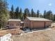 Exterior shot of a home's garage with a detached storage unit, surrounded by a natural wooded area at 28268 Shadow Mountain Dr, Conifer, CO 80433